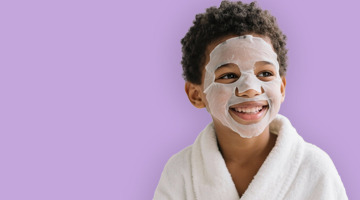 Boy in a white spa robe with a white face mask on, promoting the Fresh Reset Express Facial